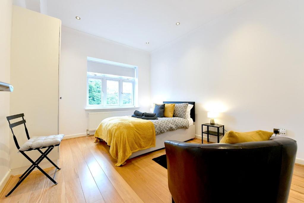 1 dormitorio con 1 cama con manta amarilla en Hendon Escape Luxury Apartment with En-suite Bath, en Hendon
