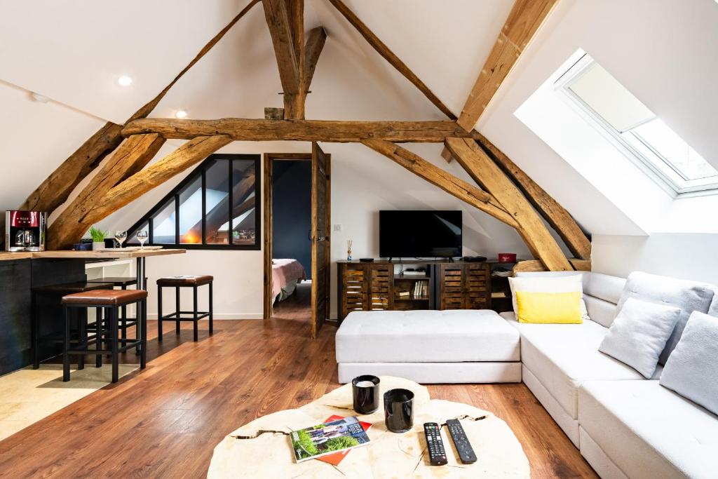 SOUS LE HAUT DES REMPARTS في بون: غرفة معيشة مع أريكة بيضاء وطاولة
