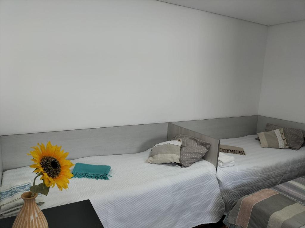 two beds in a room with a sunflower between them at Bom Caminho in Arrifana