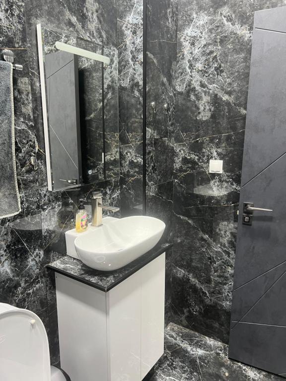 a black and white bathroom with a sink and a mirror at Saryan 2 in Yerevan