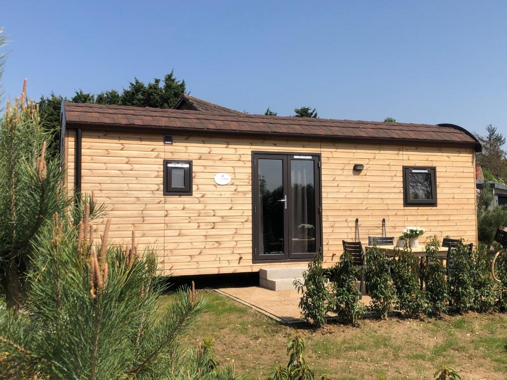 een tiny house in een tuin met een patio bij Family Woodlodge High Chaparral in Oorsbeek