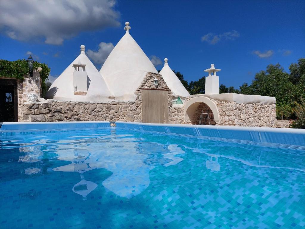 uma igreja com uma piscina em frente a uma casa em Trullo di Puglia em Ceglie Messapica