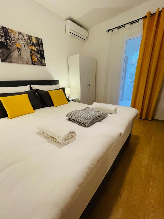 a large white bed in a room with a window at Apartmani Roko&Lovre Paklenica in Starigrad