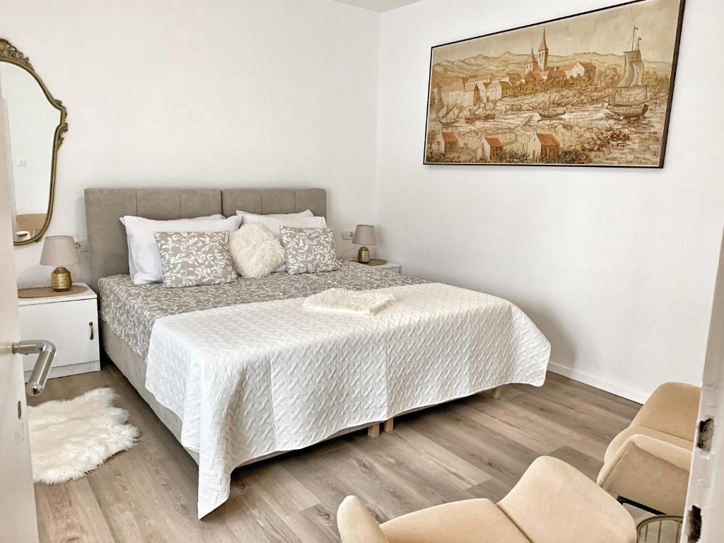 1 dormitorio con 1 cama y una pintura en la pared en Villa Nika 3, en Ika