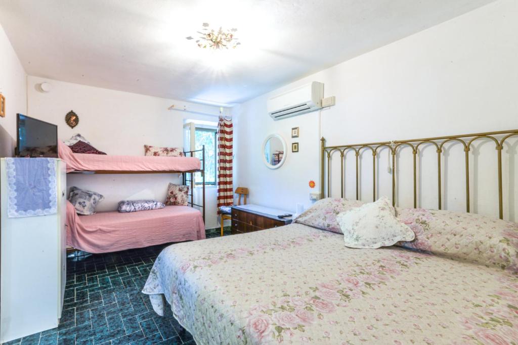 um quarto com 2 camas e lençóis cor-de-rosa em VILLETTA L'ARANCIO em Marina di Campo