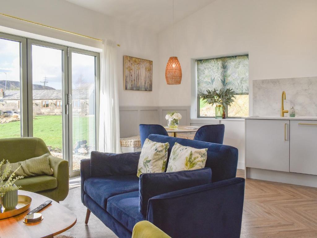 a living room with a blue couch and a table at The Stables in Littleborough