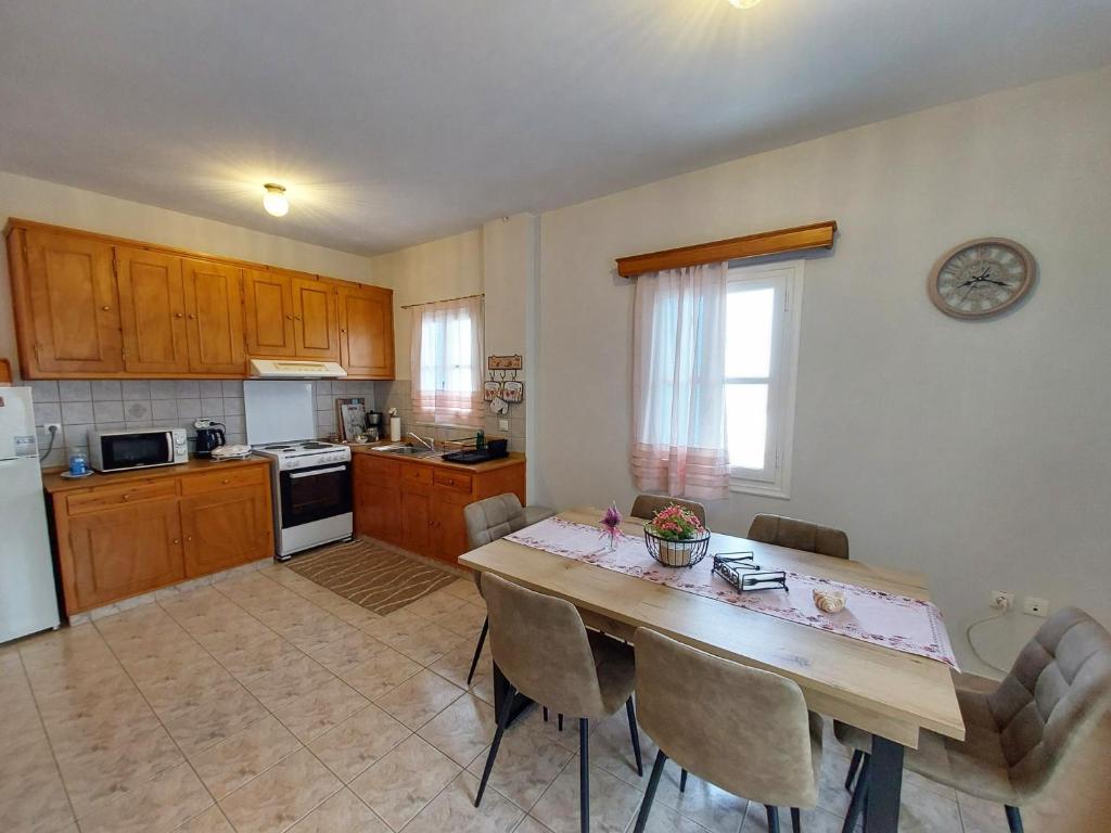 a kitchen with a table and chairs in a kitchen at Anemone Rose - Chora center in Andros