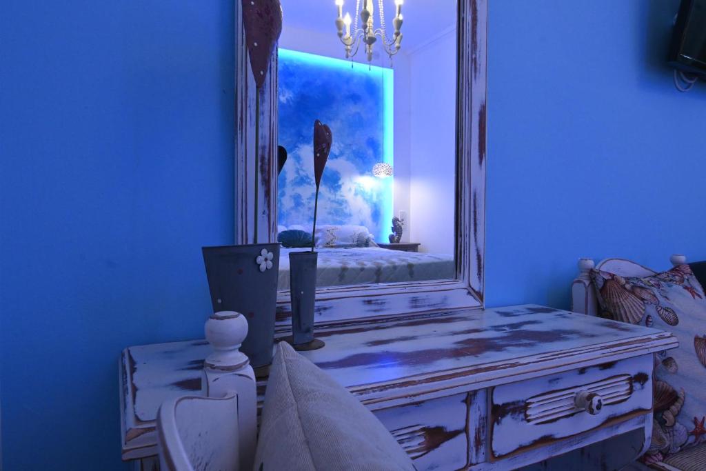 a blue room with a mirror on top of a dresser at Alisaxni Studios in Argassi