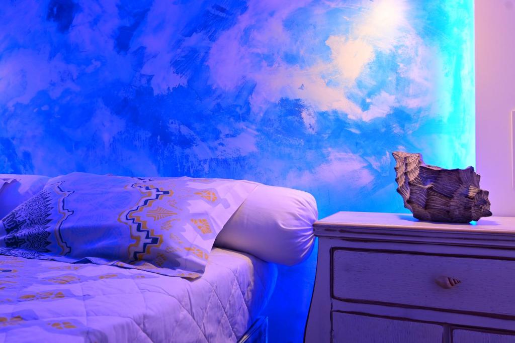 a room with a bed and a painting of clouds at Alisaxni Studios in Argassi