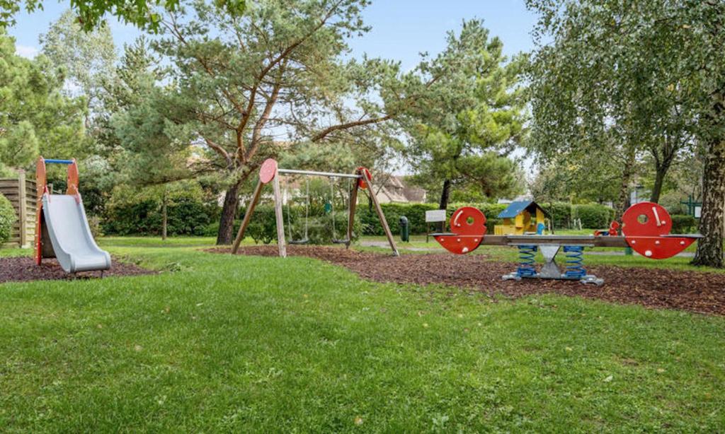 a park with two swings and a playground at Magnifique appartement 2 pièces in Deauville