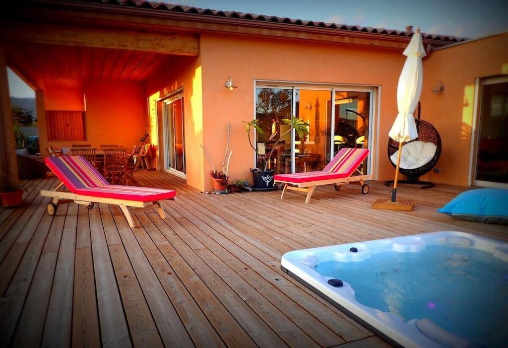 - un bain à remous installé sur une terrasse en bois avec 2 chaises dans l'établissement NEW Villa with JACUZZI, near St Cyprien beach, à Lecci
