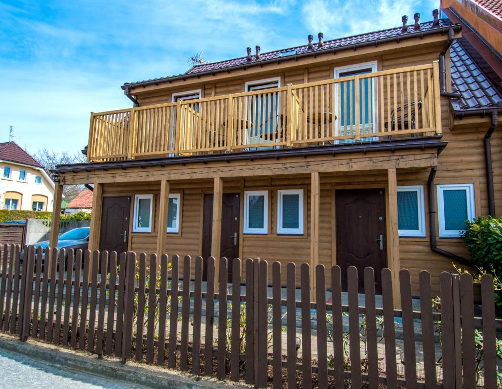 a wooden house with a deck on top at Apartamenty Przy Deptaku in Trzęsacz