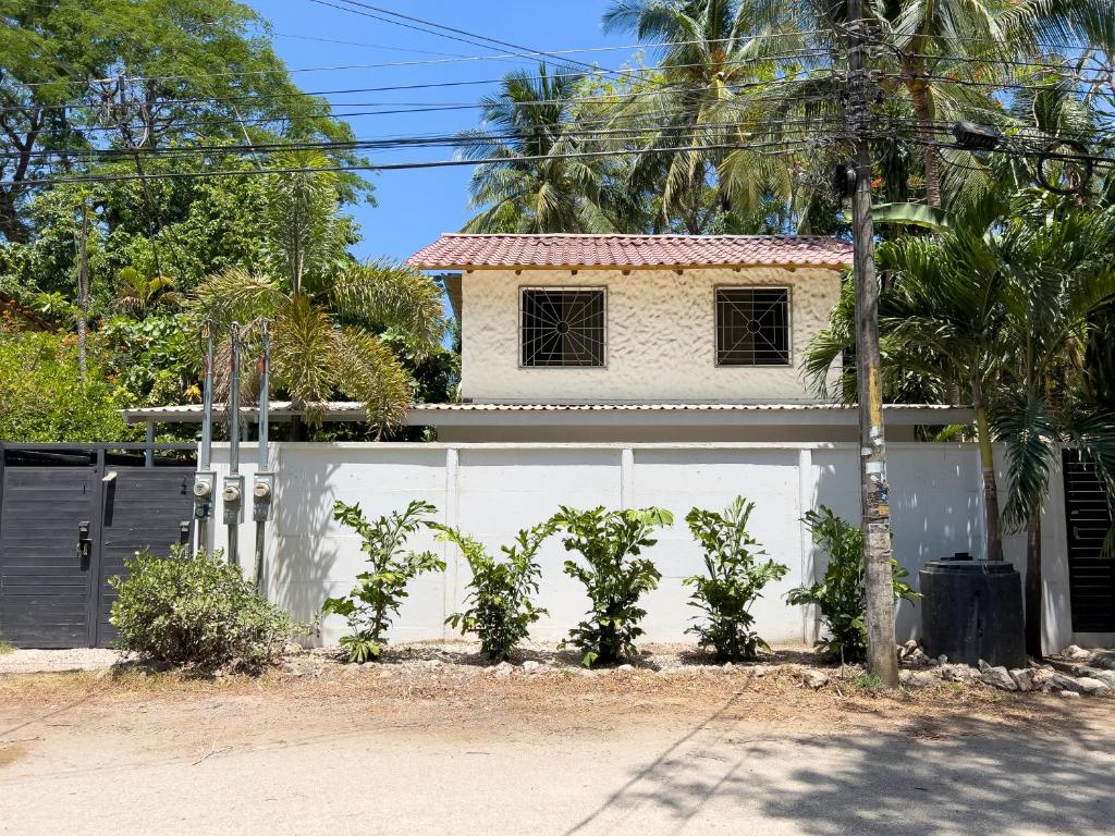 une maison avec une clôture blanche et un garage blanc dans l'établissement Salt Nosara, à Nosara