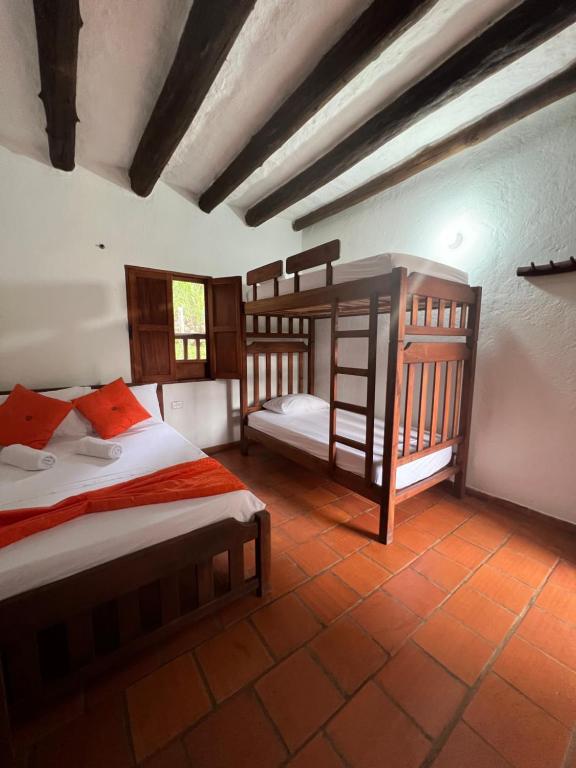 a bedroom with two bunk beds in a room at Hostal Villa San Rafael in Barichara