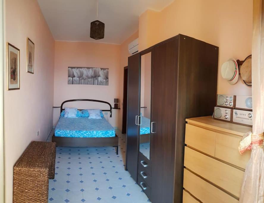 a bedroom with a bed and a dresser at Sundowner Home in Marongiu