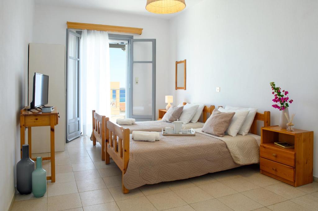 1 dormitorio con 2 camas y TV. en VIRI VIRI APARTMENTS en Lilikás