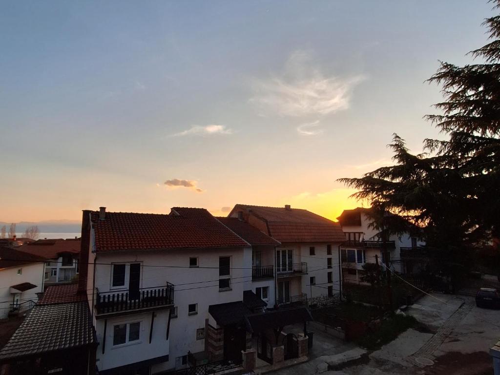 een groep huizen met de zonsondergang op de achtergrond bij Apartments Meshko in Ohrid