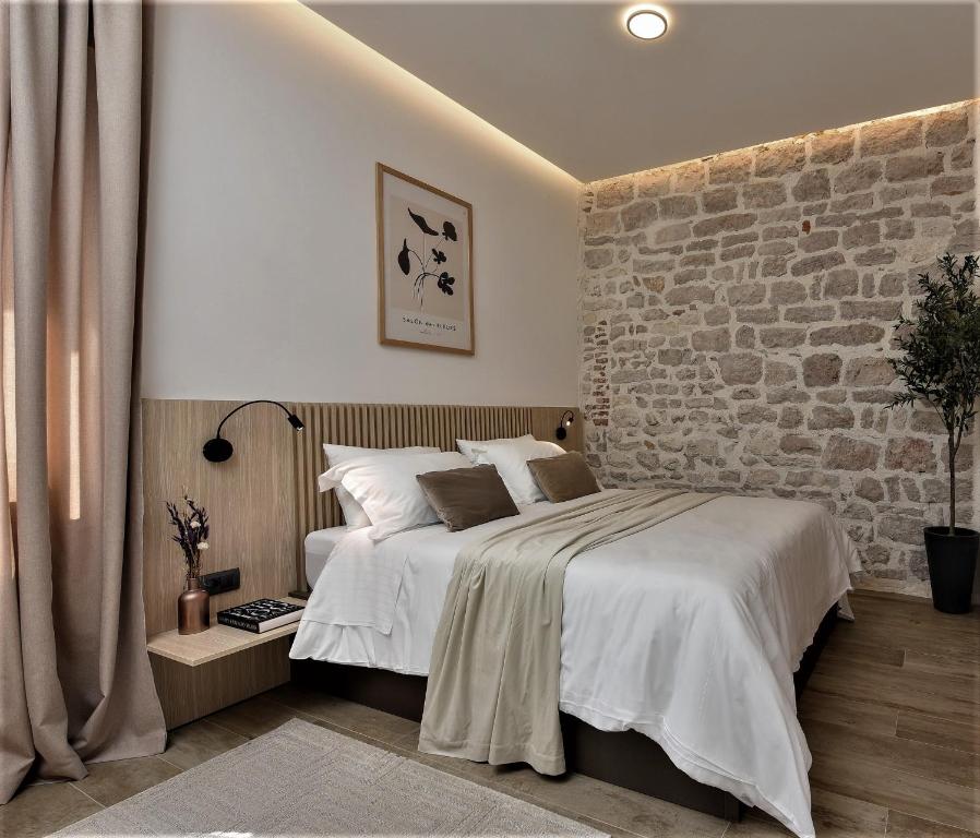 a bedroom with a bed and a brick wall at NEW!Beautiful modern bedrooms and apt Old town Zadar- Great location in Zadar