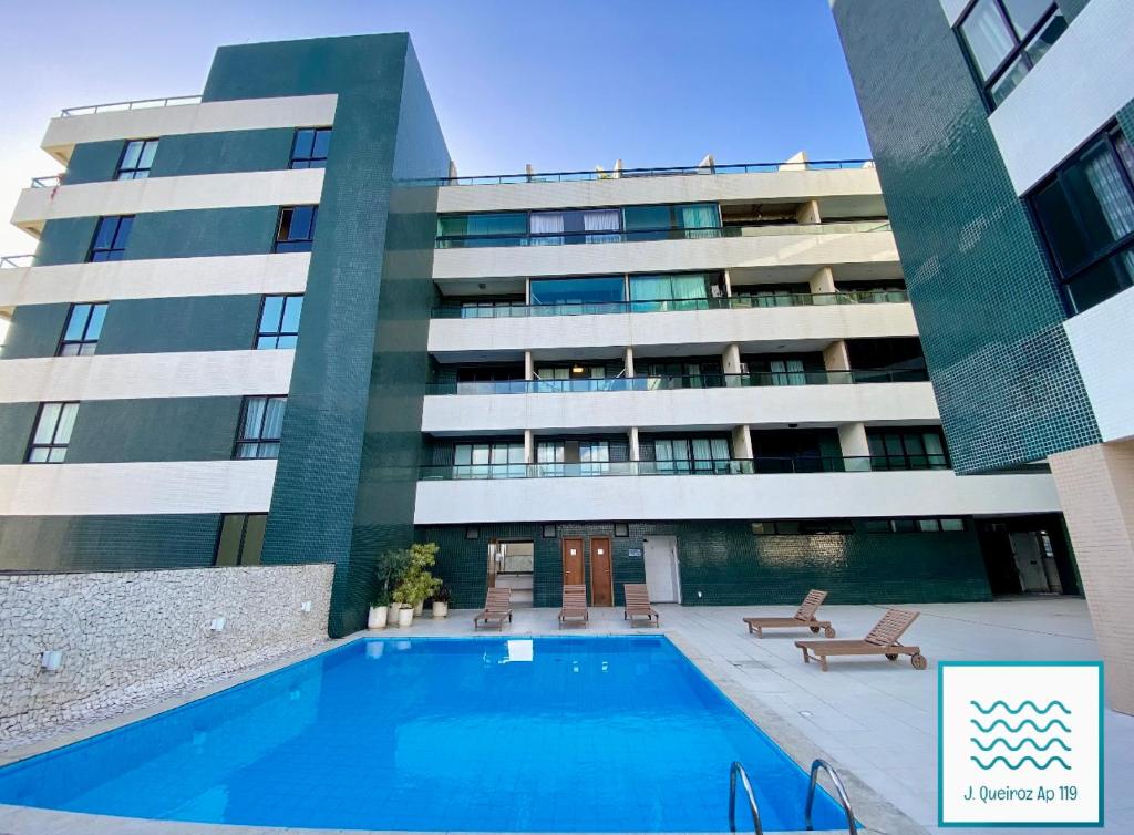 a building with a swimming pool in front of a building at Flat Luxuoso-Piscina, Praia e Serviço de Camareira in Salvador