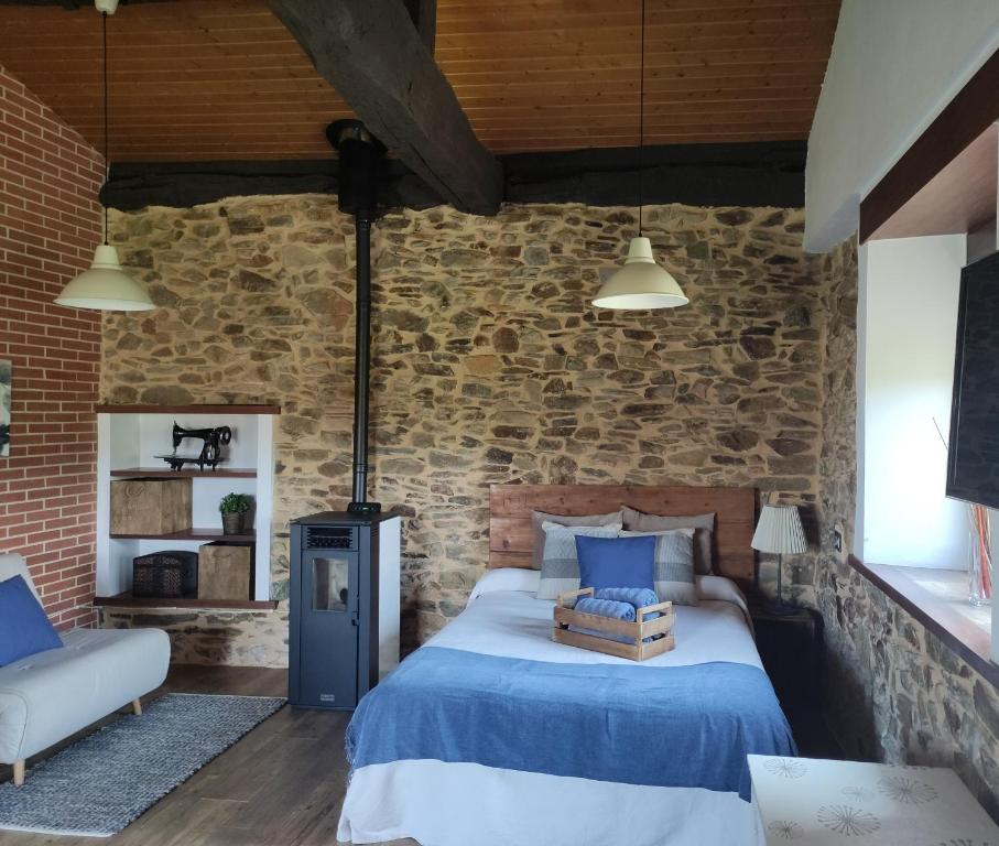 1 dormitorio con cama y pared de ladrillo en MINI PICONEIRO II, en Pravia