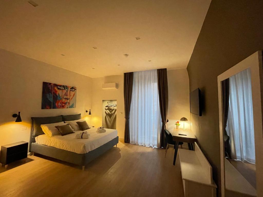 1 dormitorio con 1 cama, escritorio y ventanas en Summertime en Bisceglie