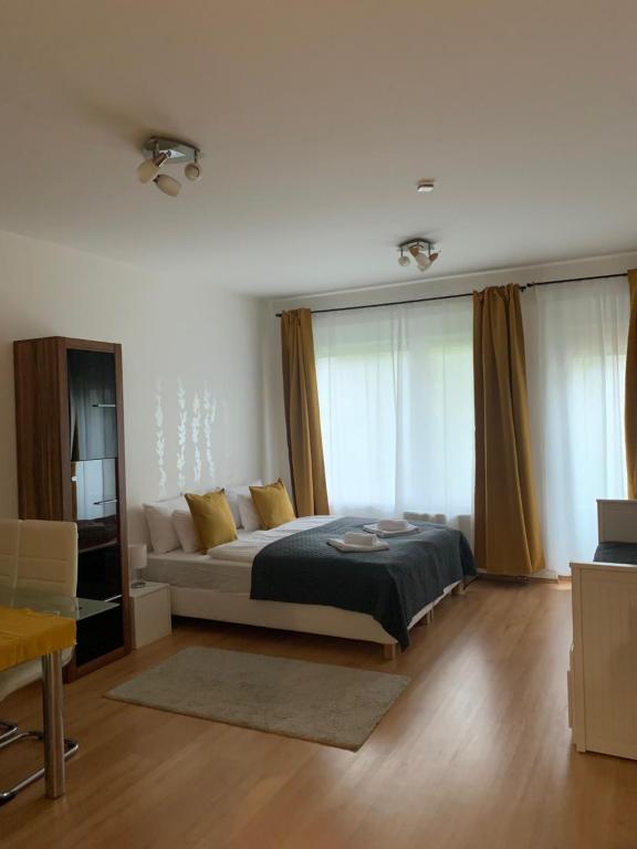 ein Schlafzimmer mit einem Bett und einem Sofa in einem Zimmer in der Unterkunft Corvin Fontana Apartment in Budapest