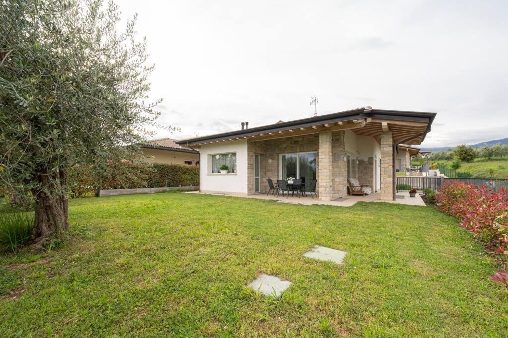 a house with a grass yard with a house at Casa Vincenzo in San Felice del Benaco