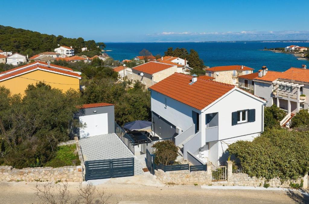 una casa blanca con techo naranja en una colina en Kuca za odmor Davorka, en Lukoran