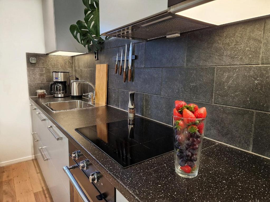 wazon wypełniony owocami na blacie w kuchni w obiekcie Ibsens apartaments w Bergen