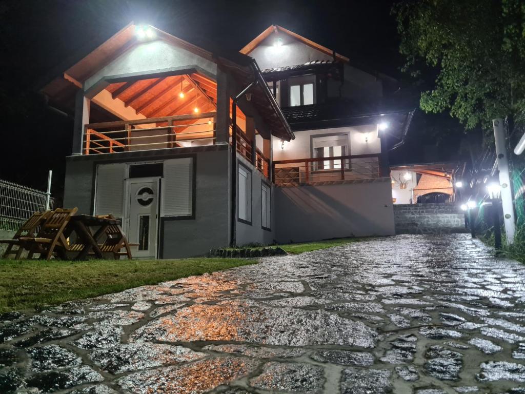 una casa di notte con una strada di ciottoli di Vila Dimitrijevic Lisine a Despotovac