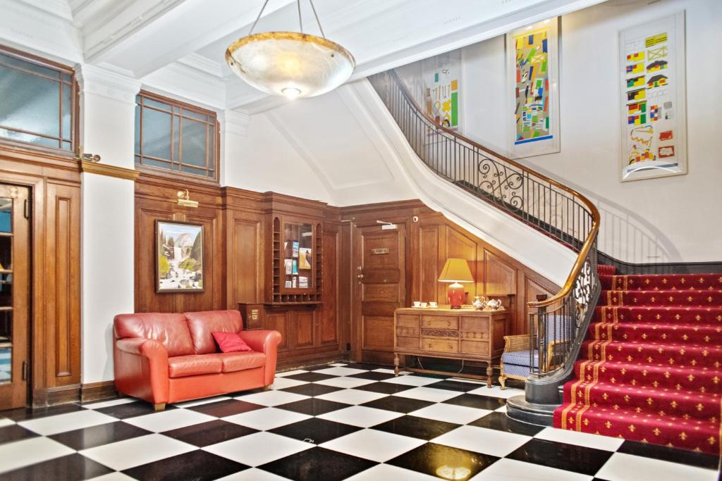 a lobby with a staircase and a red chair at Wellesley Boutique Hotel in Wellington