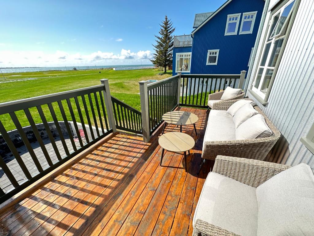 una terraza con sofá y sillas en una casa en A New house that is a mix of an Historic House ( Torfhildur Hólms House ) and a new building in heart of Reykjavik on 3 levels en Reikiavik