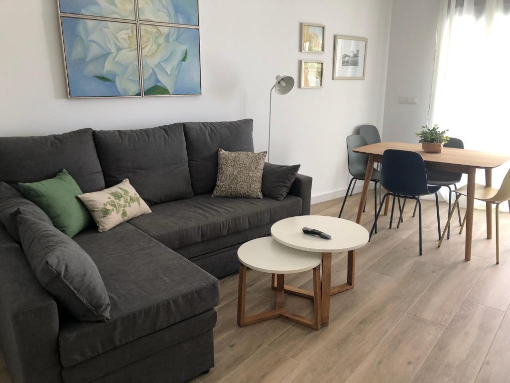 uma sala de estar com um sofá e uma mesa em Puerta del Buey Apartamentos em Niebla