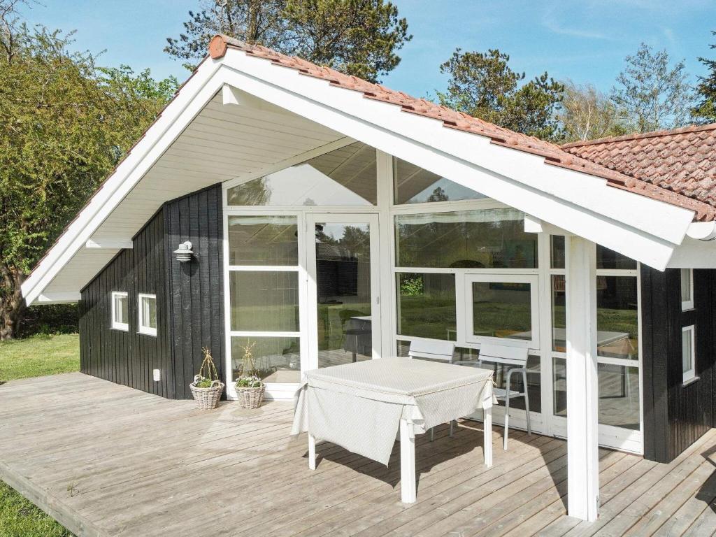 un pabellón con una mesa en una terraza de madera en 8 person holiday home in Slagelse, en Store Kongsmark