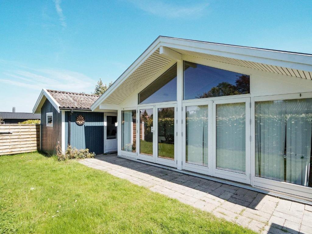 uma casa com grandes portas de vidro deslizantes num quintal em Holiday home Holbæk XV em Holbæk