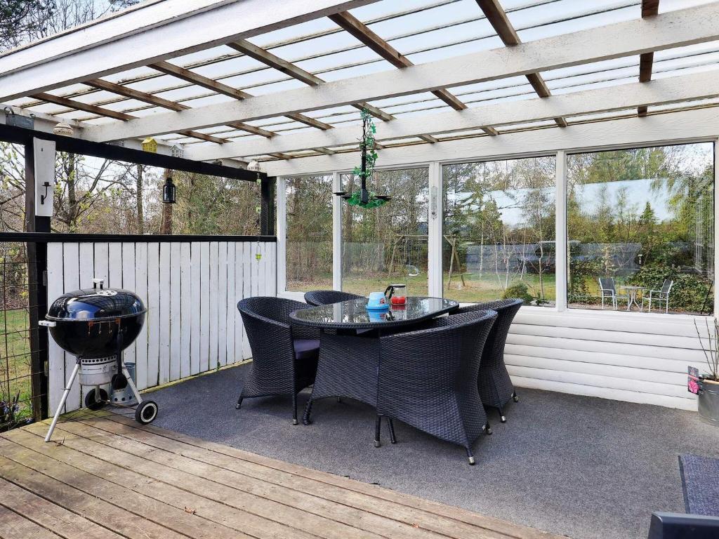 een patio met een tafel en stoelen en een grill bij Holiday home Hals XIV in Hals