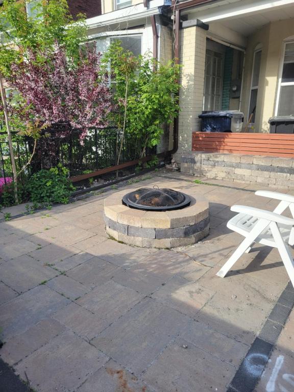 a fire pit in a patio in front of a house at 4 Bedroom 3 bathroom 6 queen bed 5 full floor mattress with backyard Whole house for travel or vacation public and celebration group gatherings in Toronto