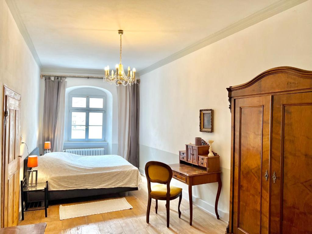 1 dormitorio con cama, escritorio y silla en Oswald Hempel 5 Zimmermaisonette und 3 Zimmer Loftwohnung, en Zittau