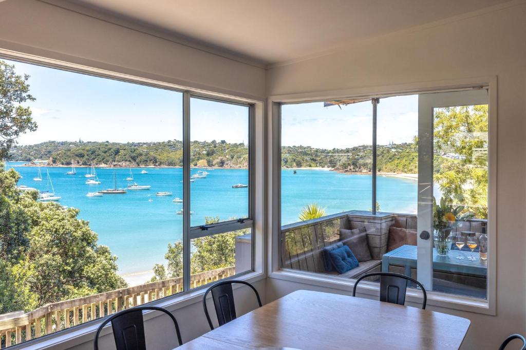 a dining room with a view of the ocean at Oneroa Beach Hideaway in Blackpool