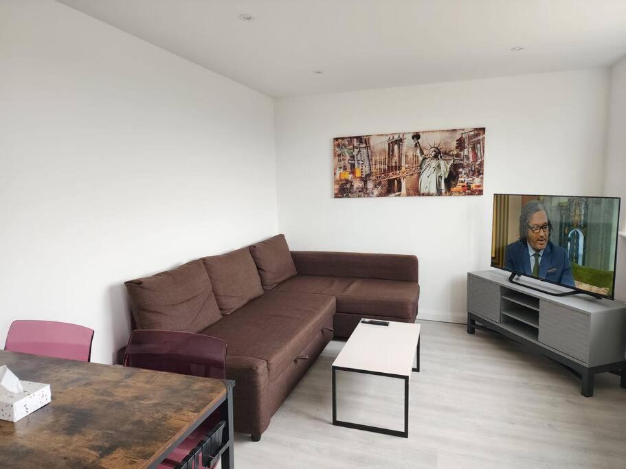 a living room with a brown couch and a tv at Hazel 1-Bed Flat (4) + Parking in Kidlington