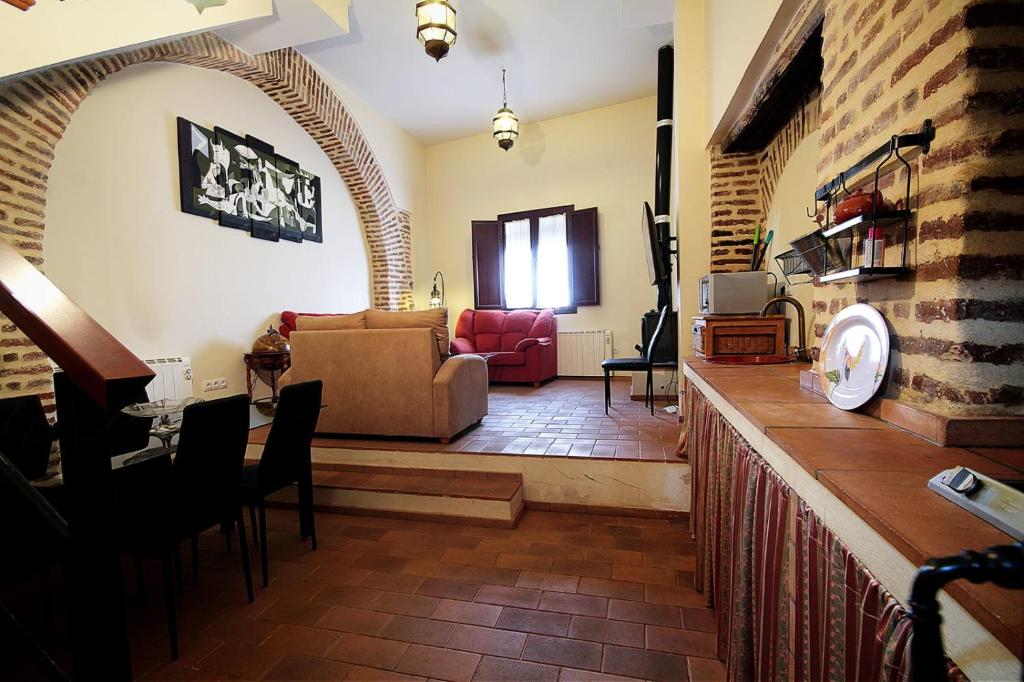een woonkamer met een bank en een tafel bij Alojamiento rural la fábrica de palos in Cazalla de la Sierra