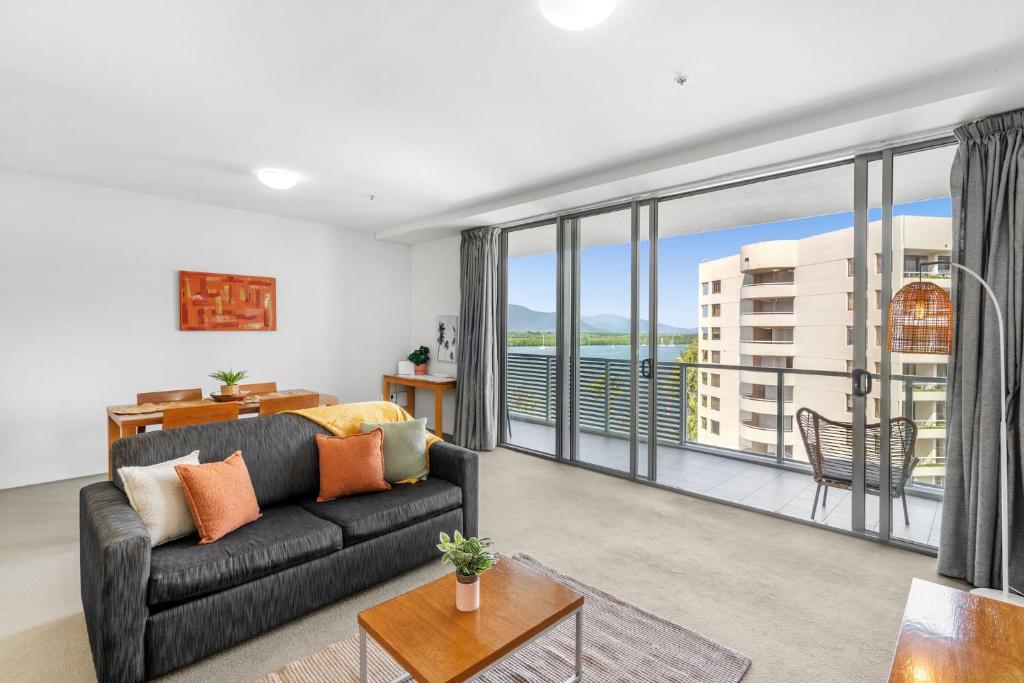 a living room with a couch and a large window at 703 Harbour Lights Cairns Apartment with water views in Cairns