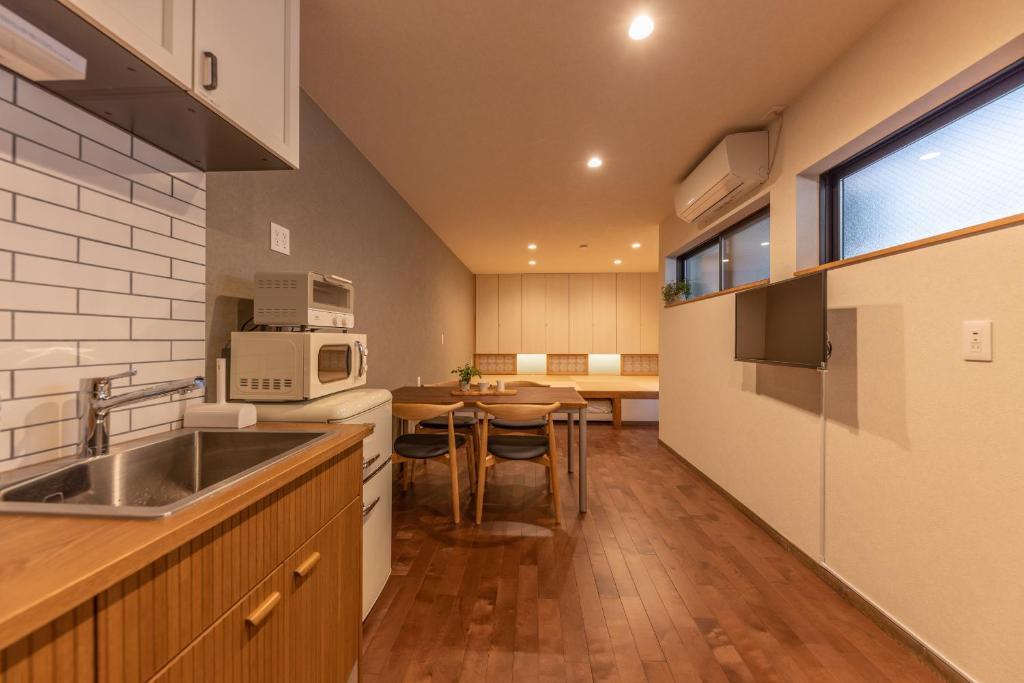 a kitchen with a sink and a table in it at KAjette - Takayama Apartment Hotel in Takayama