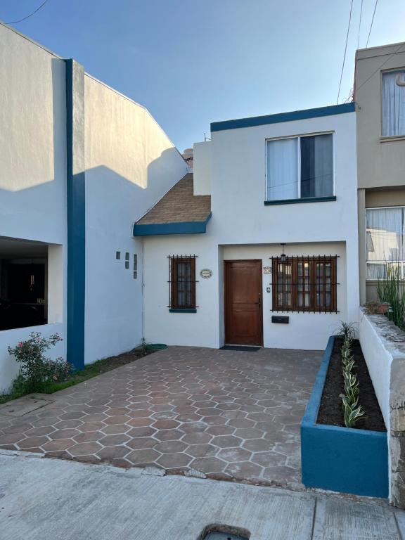 a white and blue house with a driveway at Casa Mediterraneo in Ensenada