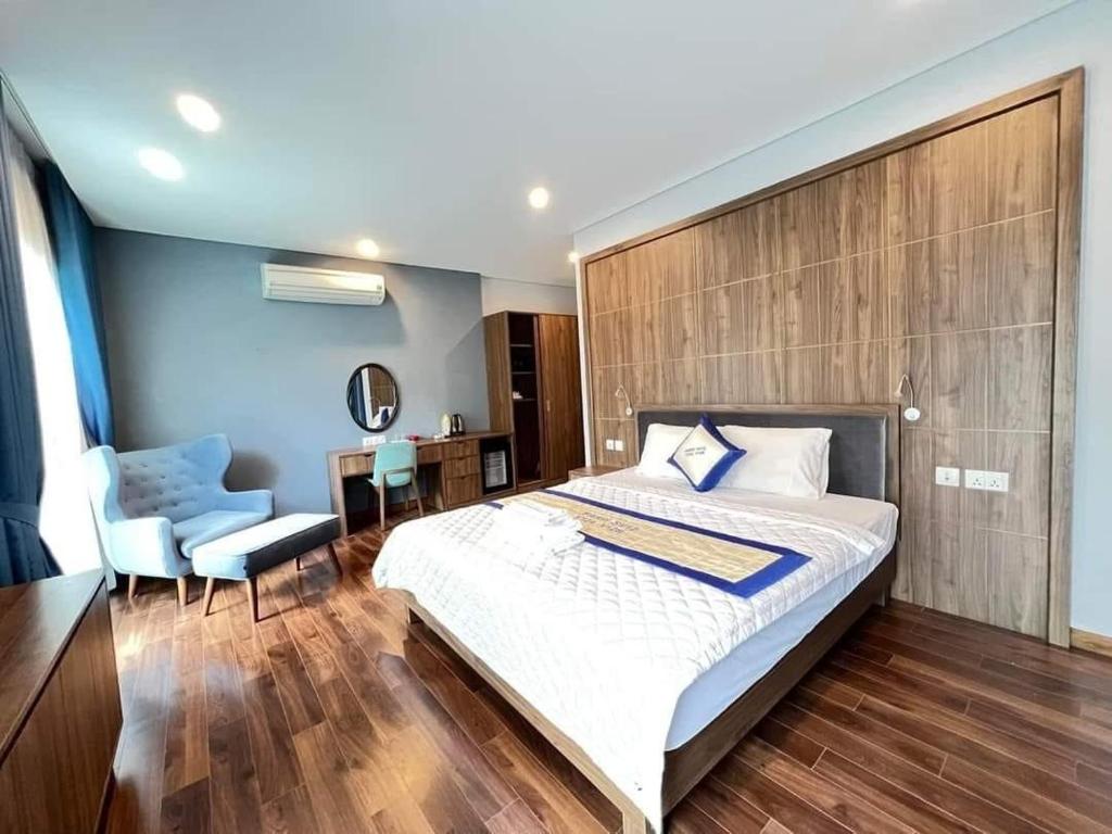 富國的住宿－Hoang Hai Villas 7 Phu Quoc - 4 Bedrooms - Shared Swimming Pool，一间卧室配有一张大床和一把椅子