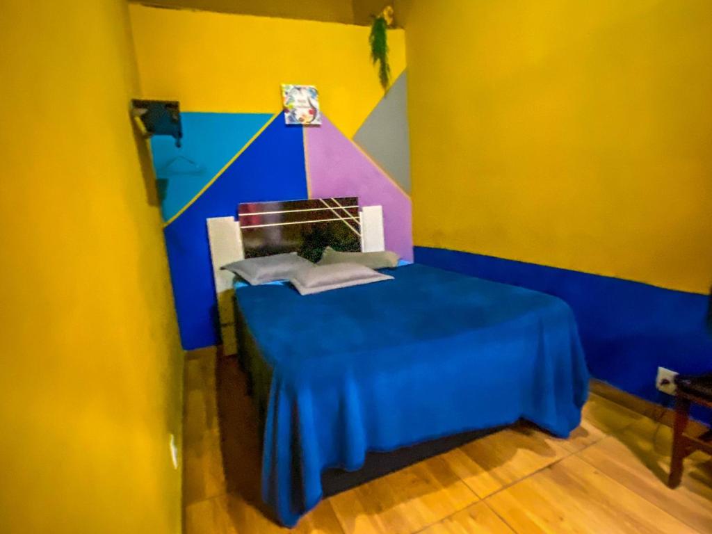 una camera con un tavolo blu e una parete colorata di Recanto Taquari - Praia e cachoeira a Parati