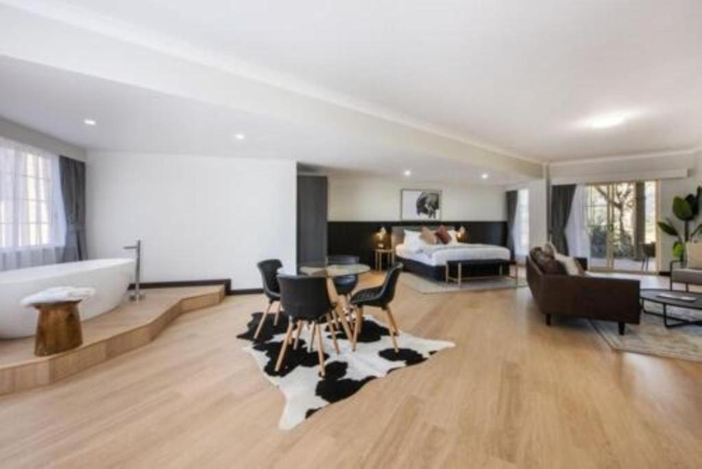 a large living room with a tub and a bedroom at Parklands Resort in Mudgee