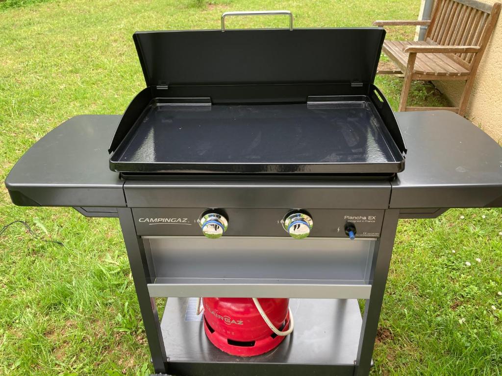 grill z czerwoną butelką na nim w obiekcie Gîte des Combes Blanches avec piscine et jacuzzi w mieście Frayssinet-le-Gélat