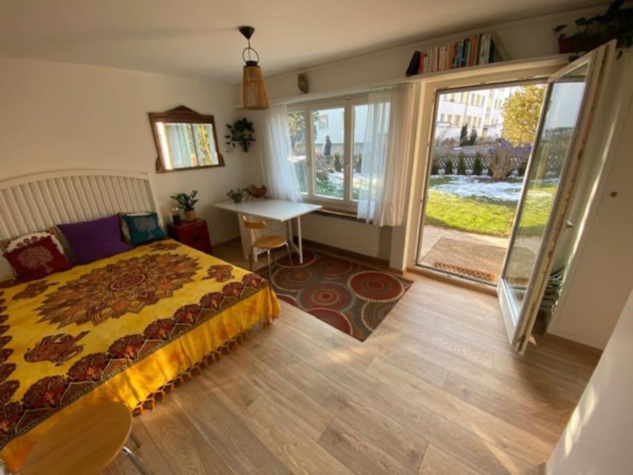 sypialnia z łóżkiem, stołem i oknem w obiekcie Pipin’s Studio w mieście Ostermundigen