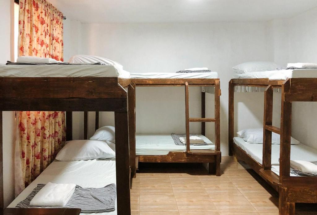 a room with three bunk beds in it at Magabelle Guesthouse in Cebu City